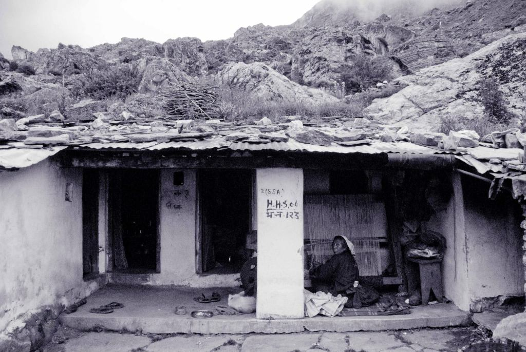 Rustic house below a rocky hillside