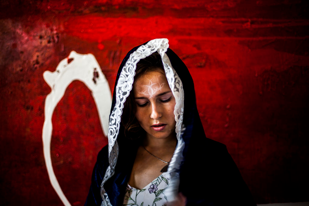 Hooded woman against a red wall